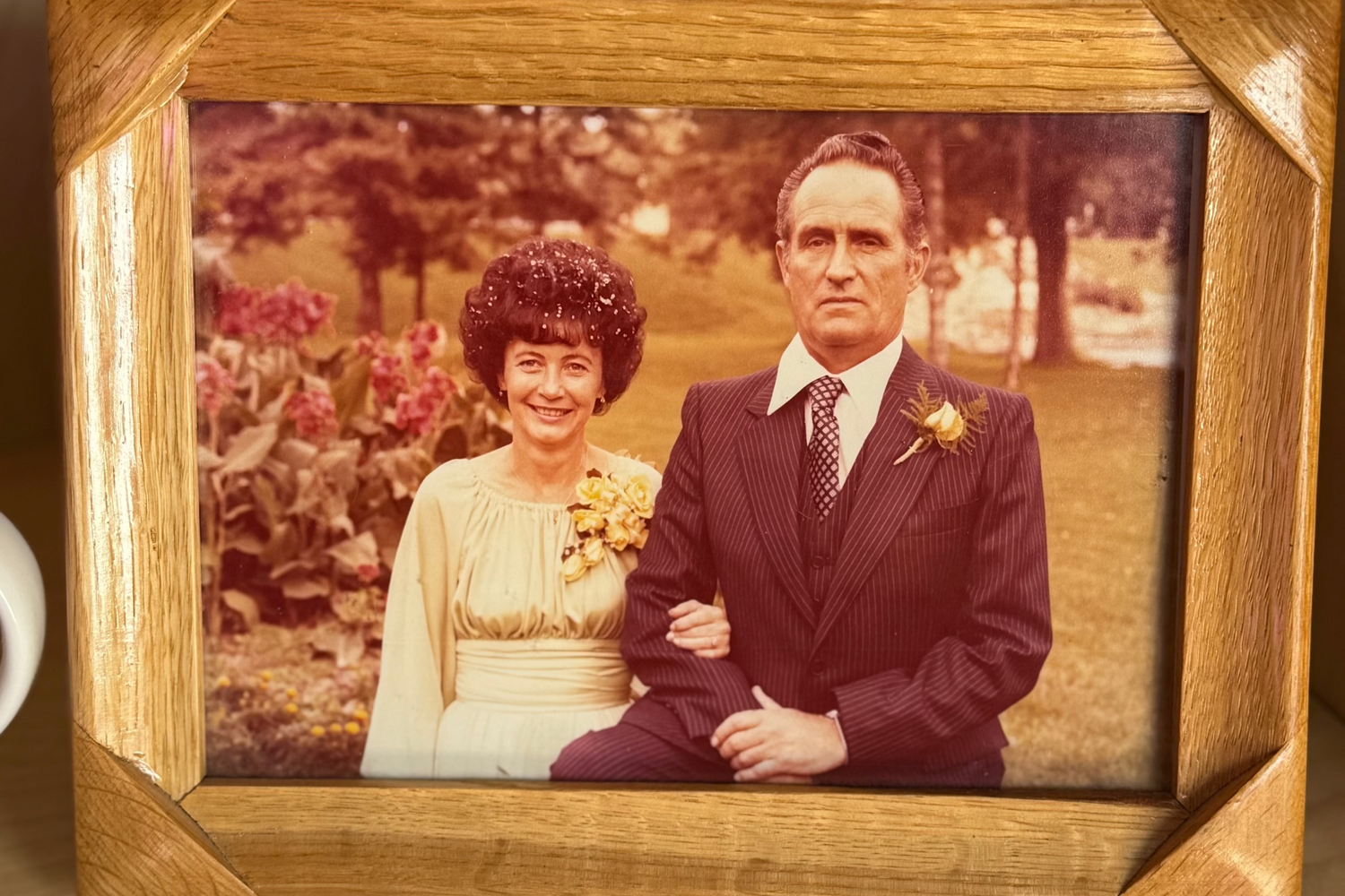 Vintage photograph of a couple in a wooden frame on a wooden surface
