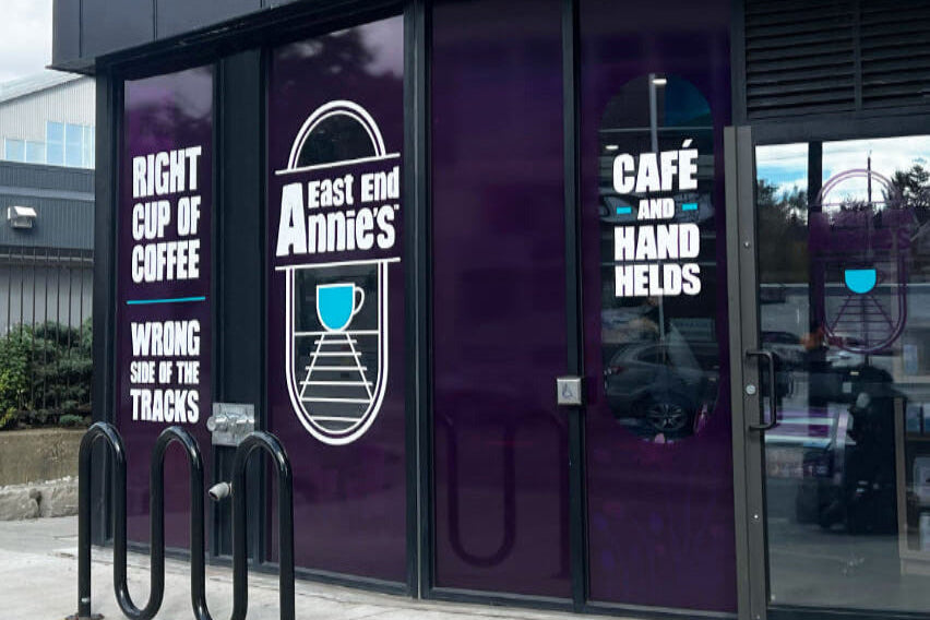 Storefront with 'East End Annie's' branding and promotional text on glass doors.