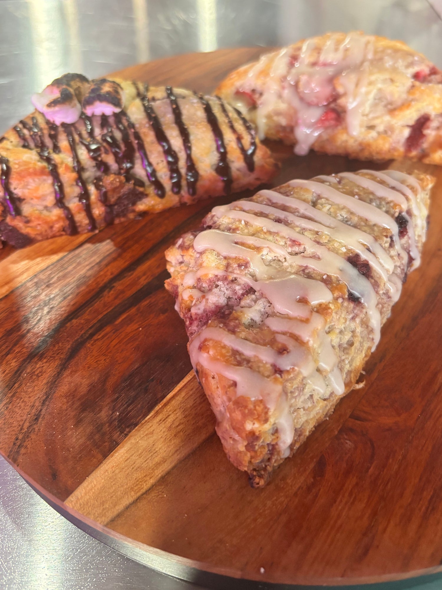 Three scones with different toppings on a wooden board